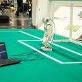 A robot connected to a computer on a soccer field. A robot connected to a computer on a soccer field.
