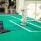 A robot connected to a computer on a soccer field.