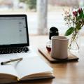 A laptop and a notebook on a desk