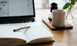 A laptop and a notebook on a desk