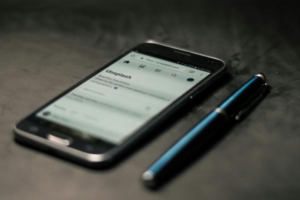 A smartphone and a pen on a desk