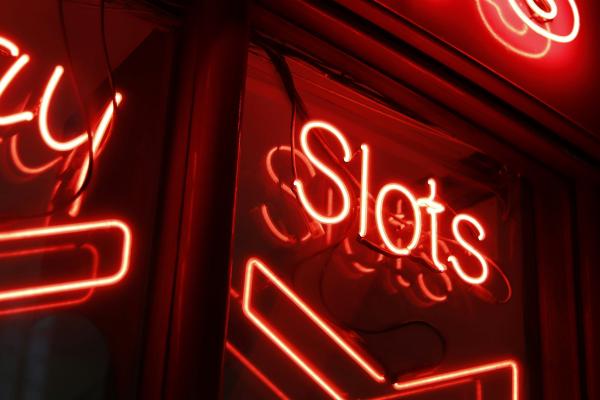 A red slots sign on the dark.