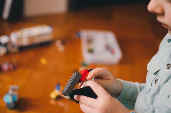 A kid building something with LEGO blocks.