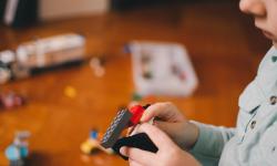 A kid building something with LEGO blocks.