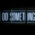 A neon sign displaying “Do Something Great”