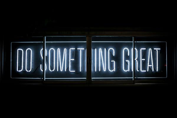 A neon sign displaying “Do Something Great”