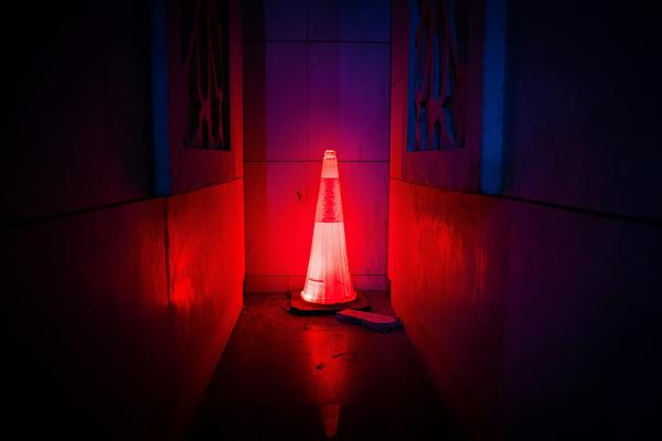 An illuminated red road work cone