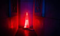 An illuminated red road work cone