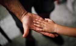 A child hand on an adult hand