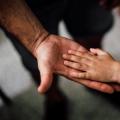 A child hand on an adult hand