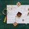 Tools, glue and piece of a prototyped box on a sheet of paper with drawing and dimensions