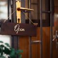 An “open” sign hanging on a wood door
