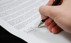 A person signing a document.