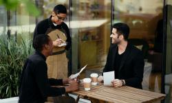 A waiter taking an order from two men