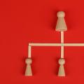 Wooden peg figures forming an organizational hierarchy chart