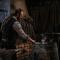 A skilled blacksmith working in his rustic workshop, crafting metal with traditional tools.